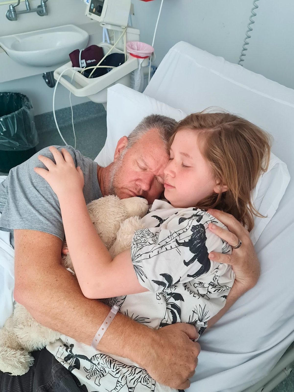 Craig embracing one of his children in a hospital bed