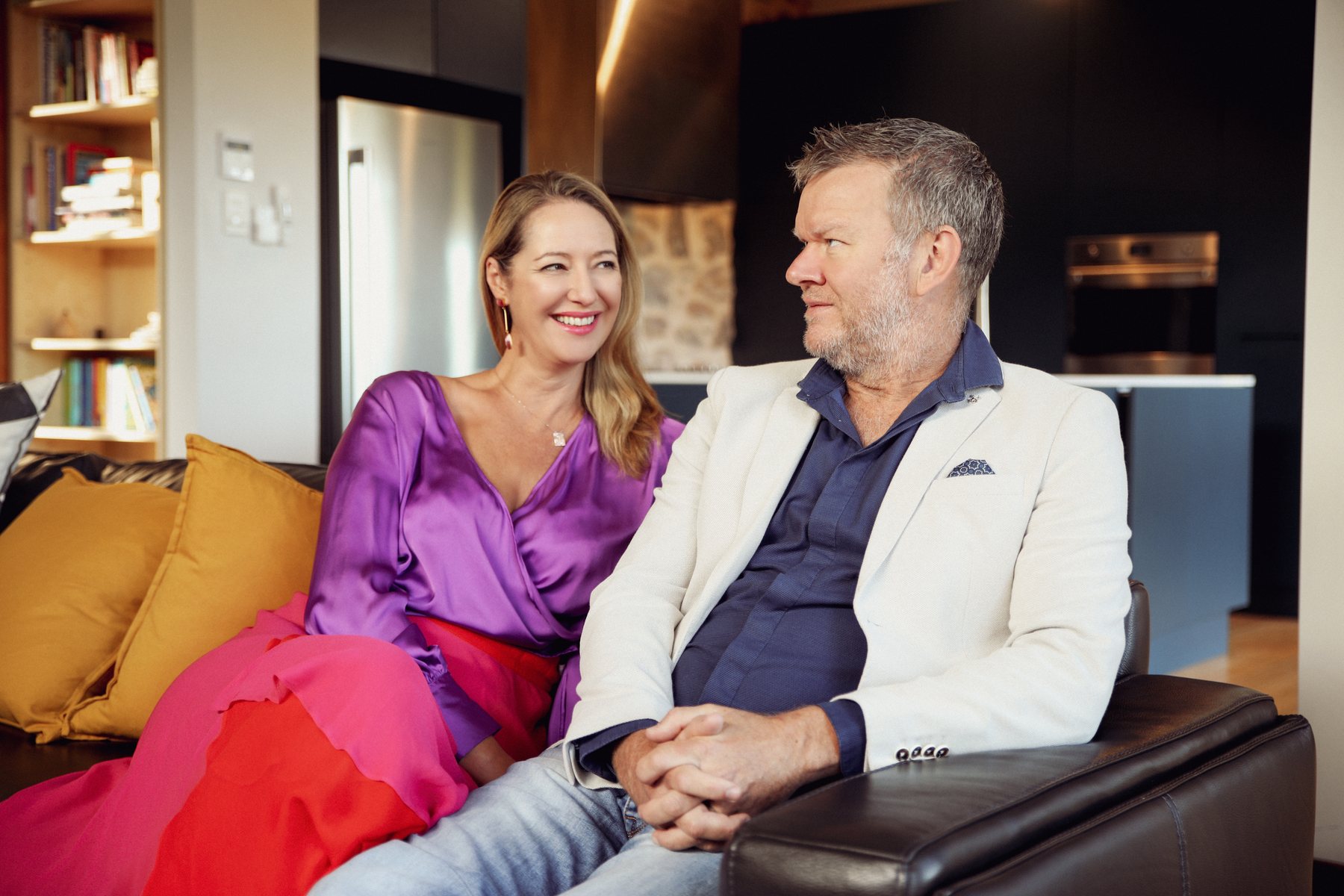 Craig Swanger and Trenna Probert seated together on a sofa, sharing a relaxed conversation
